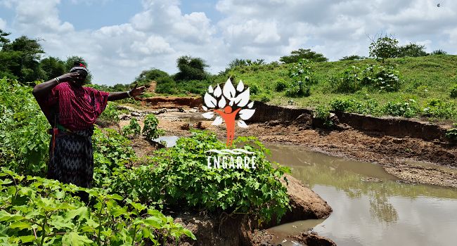 head of village showing torn dam in tanzania