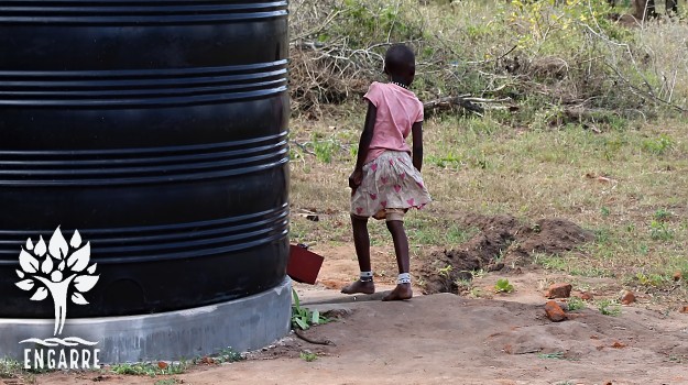 dieťa pri vodnom tanku v Tanzánii