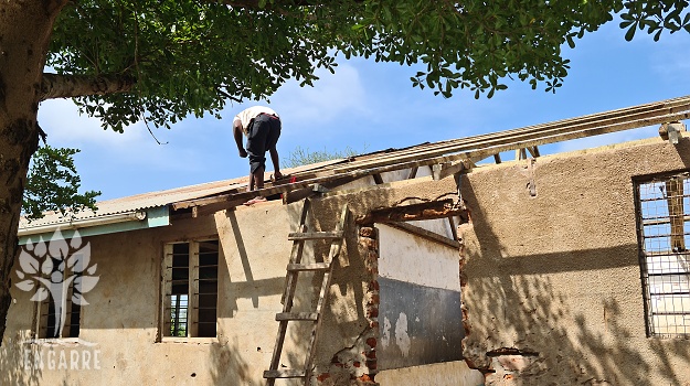 man repairing roof on school in Africa